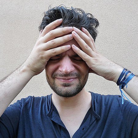 Pessoa com as mãos na cabeça, em sinal de confusão ou preocupação, simbolizando o conflito teológico.